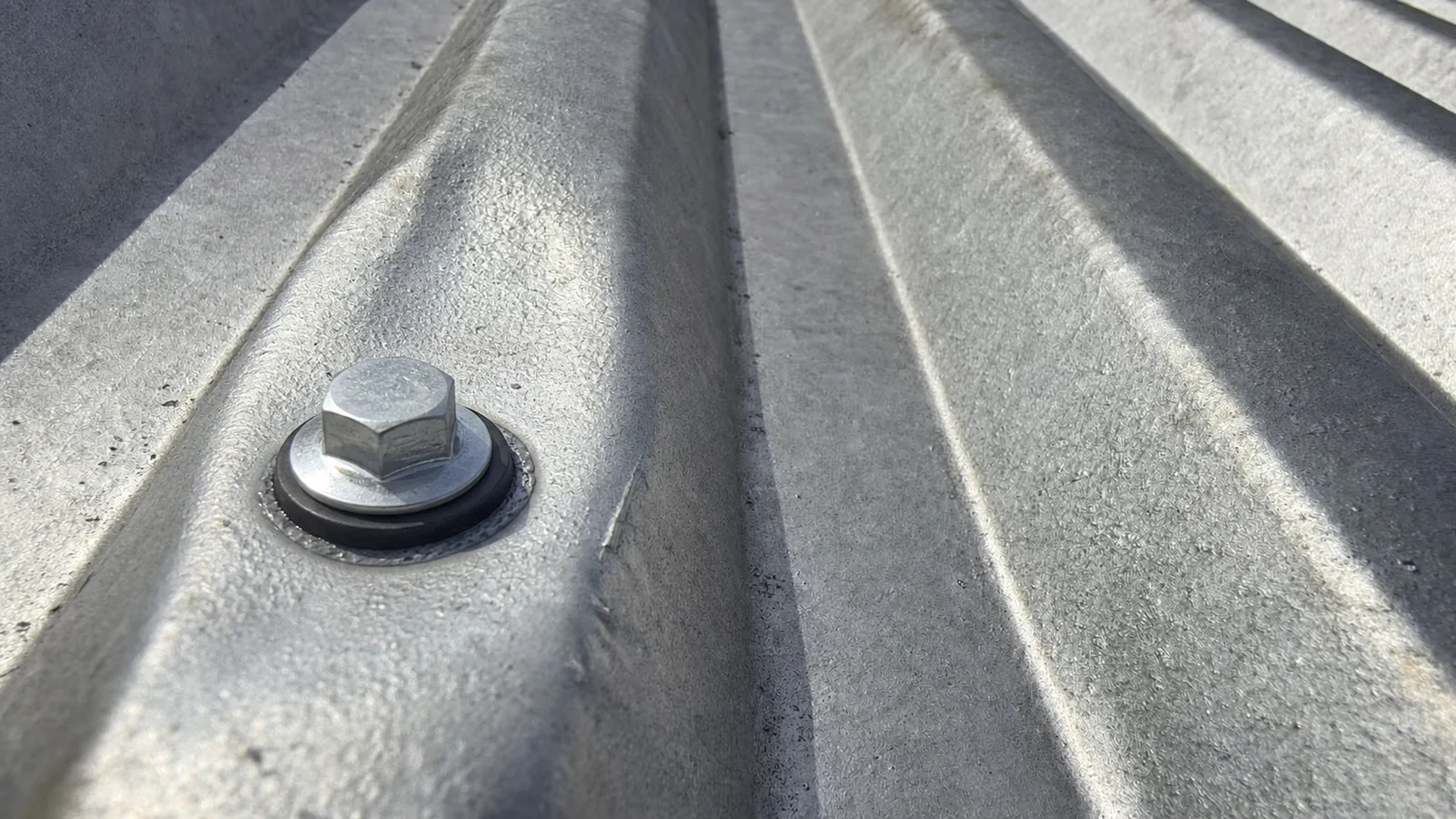 Matching view of the same metal roof rib with a neat replacement fixing and local seal
